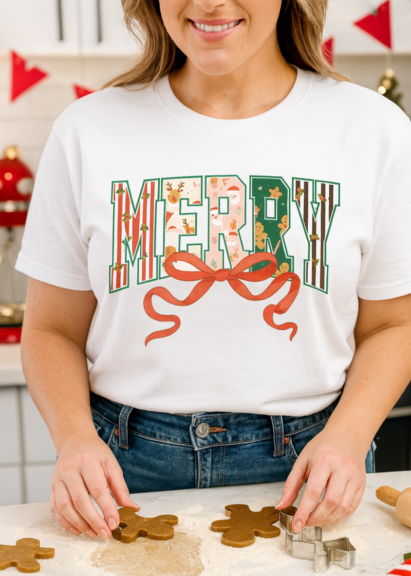 Person wearing a festive 'Merry' shirt making gingerbread cookies.
