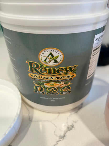 A white plastic tub of Av Vitality Renew Collagen Protein dietary supplement, featuring a dark green label with gold and white text, set on a white marble countertop.