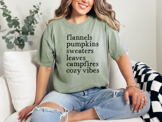 Woman wearing a green t-shirt with text, sitting on a couch.