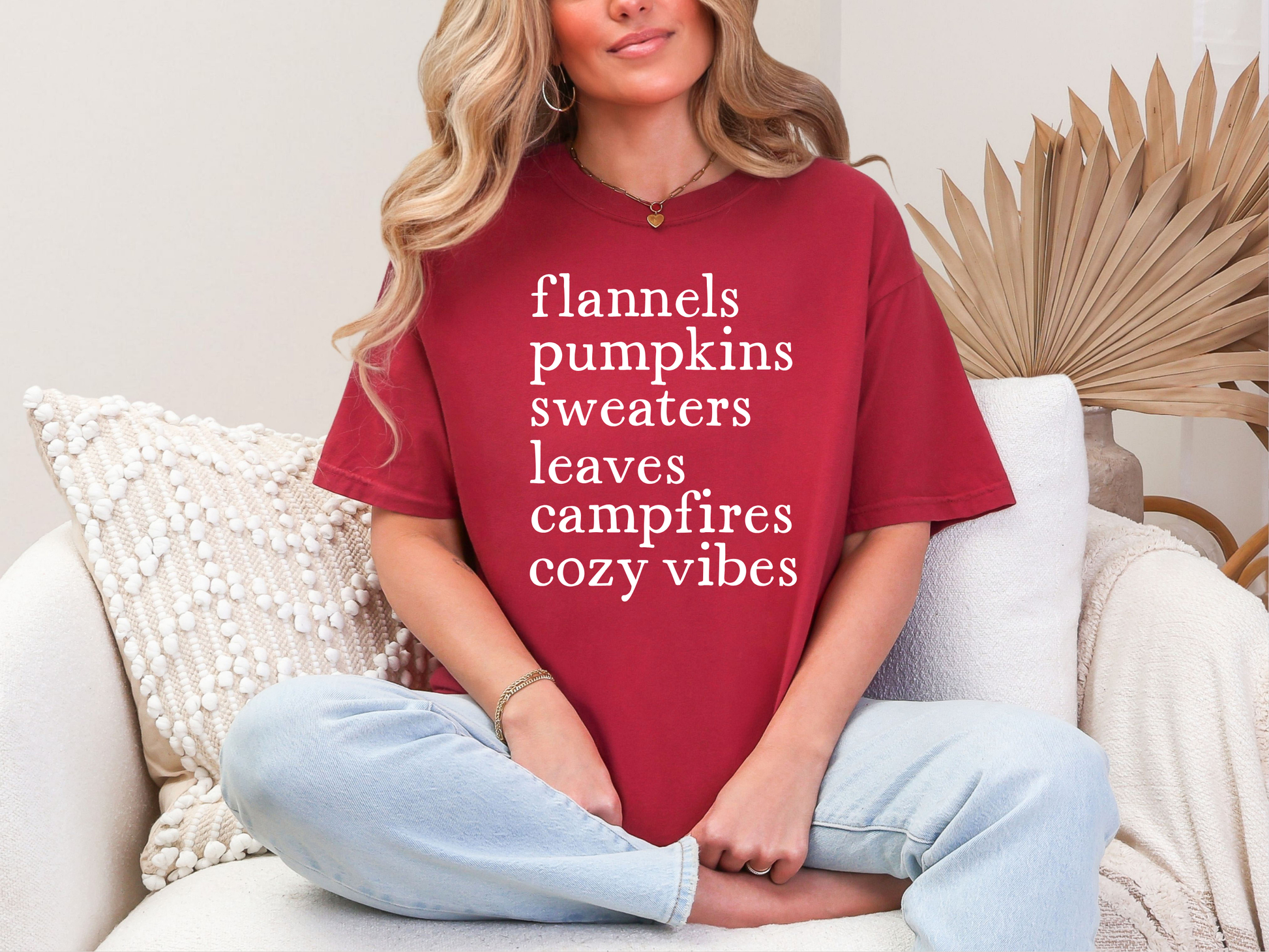 Person wearing a red t-shirt with text, sitting on a couch.