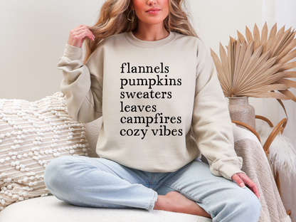 Person wearing a beige sweatshirt with text, sitting in a cozy room.